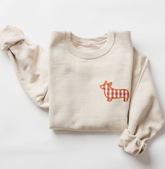 Beige sweatshirt with a orange and white corgi dog graphic on a white background